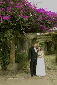 Foto novios de pie en parque