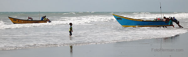 Foto niño y pescadores en playa