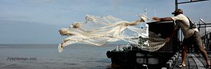 Pescador lanzando red al mar