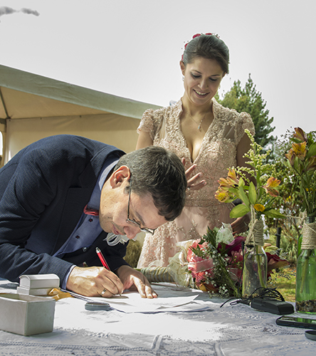 Novio firma acta matrimonio civil, novia mira